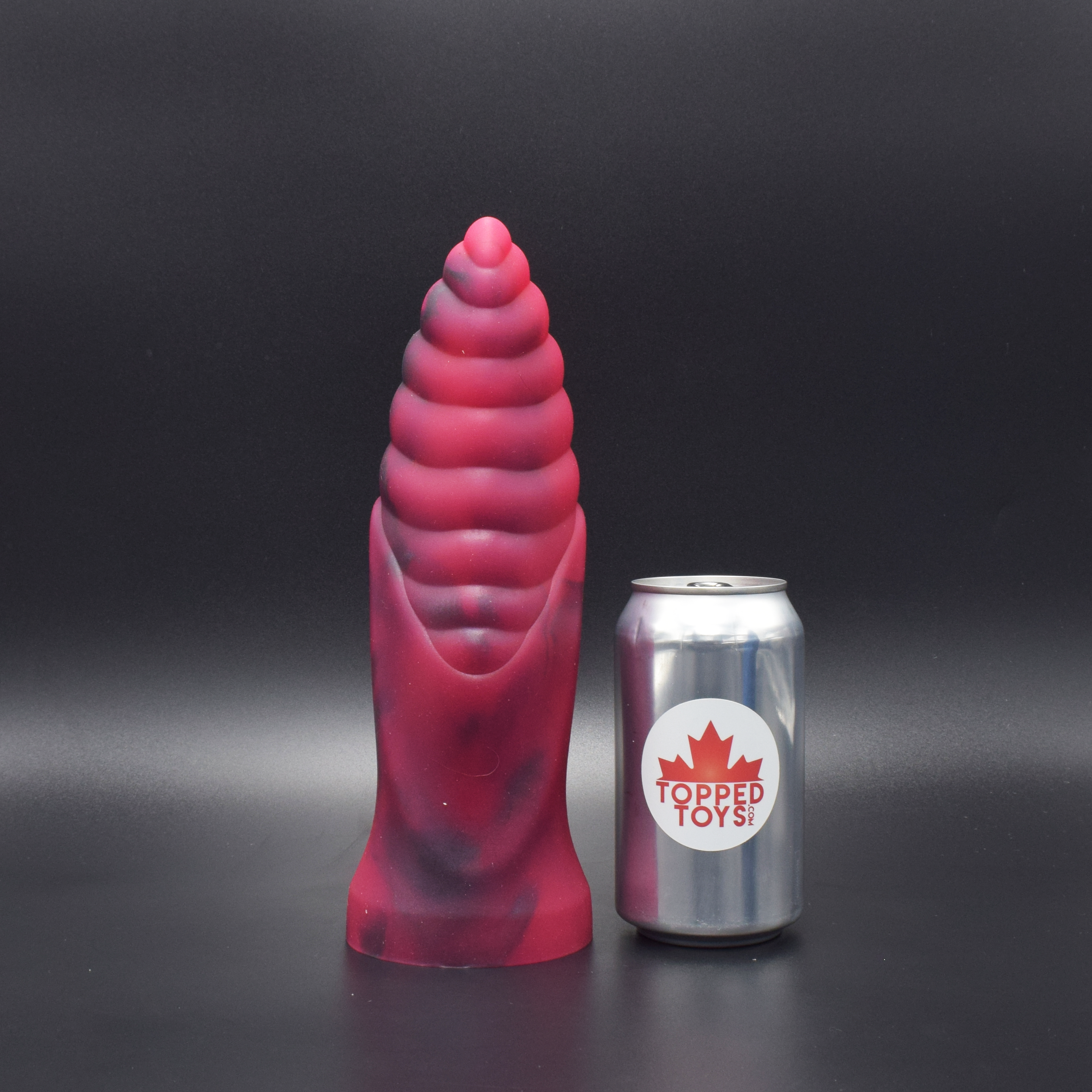Cetos 90 in Forge Red facing forward, next to pop can with Topped Toys logo
