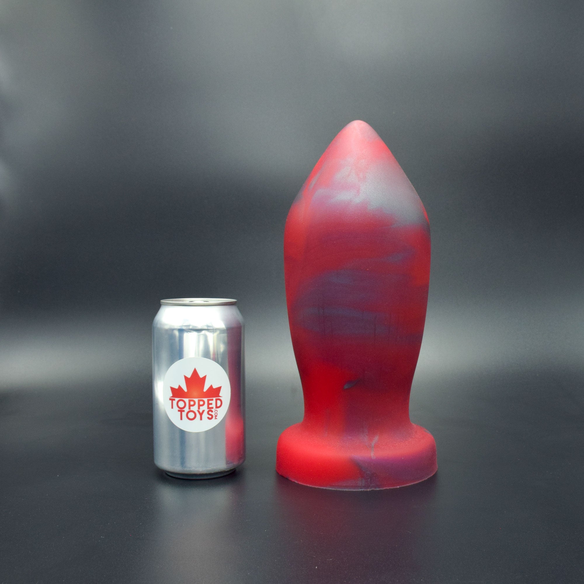 Deep Space 130 in Forge Red standing up, next to pop can with Topped Toys logo