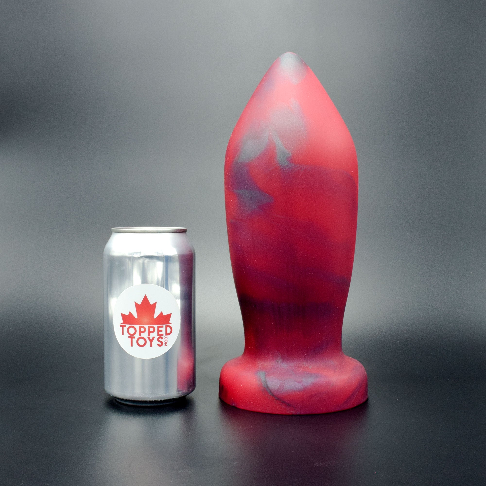Deep Space 120 in Forge Red standing up, next to pop can with Topped Toys logo
