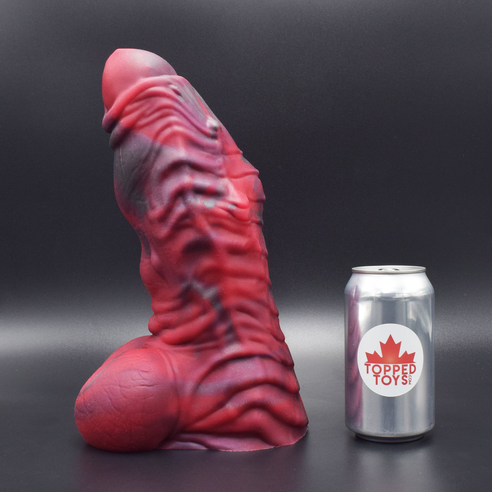 Erebus 120 in Forge Red facing left to show detail, next to pop can with Topped Toys logo