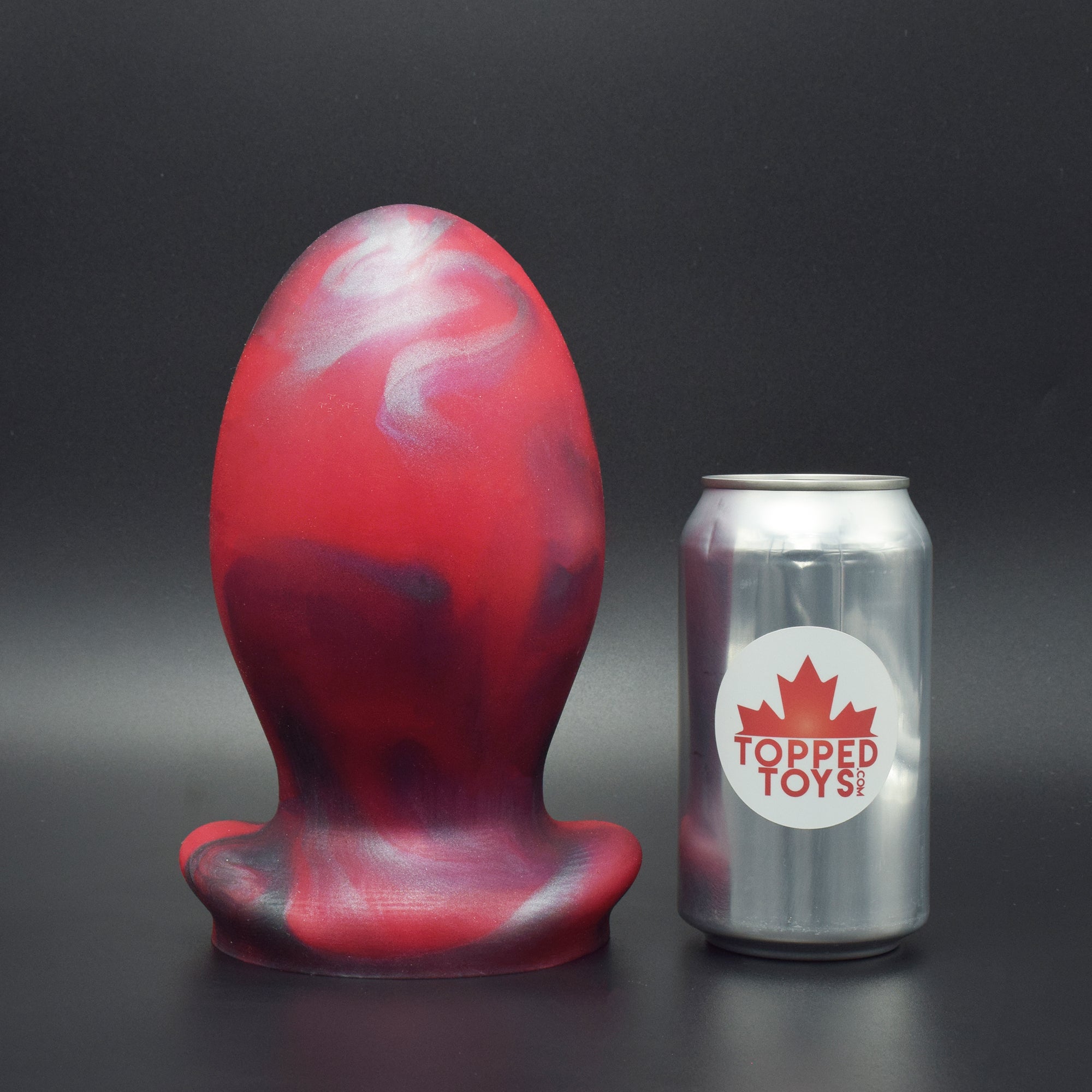 Gape Keeper 128 in Forge Red, next to pop can with Topped Toys logo