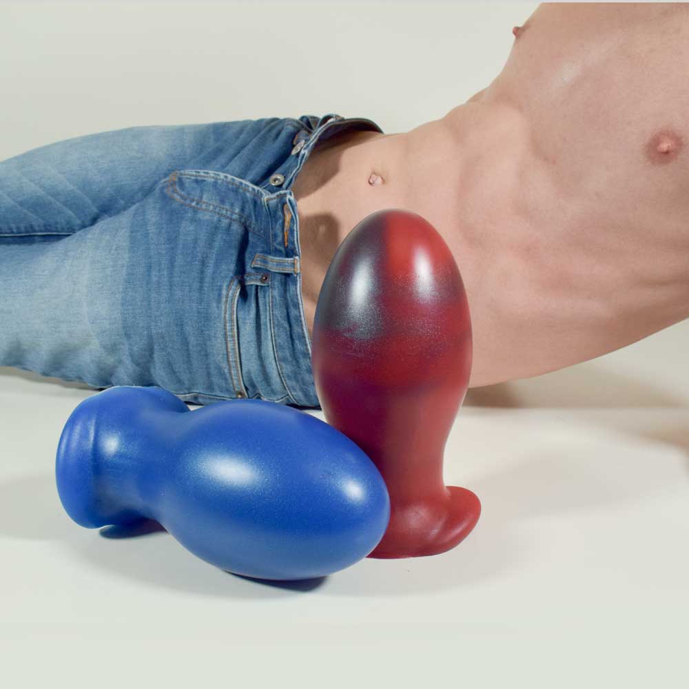 Gape Keeper 116 in Blue Steel laying on its side, and Gape Keeper 116 in Forge Red standing up, with Model posing