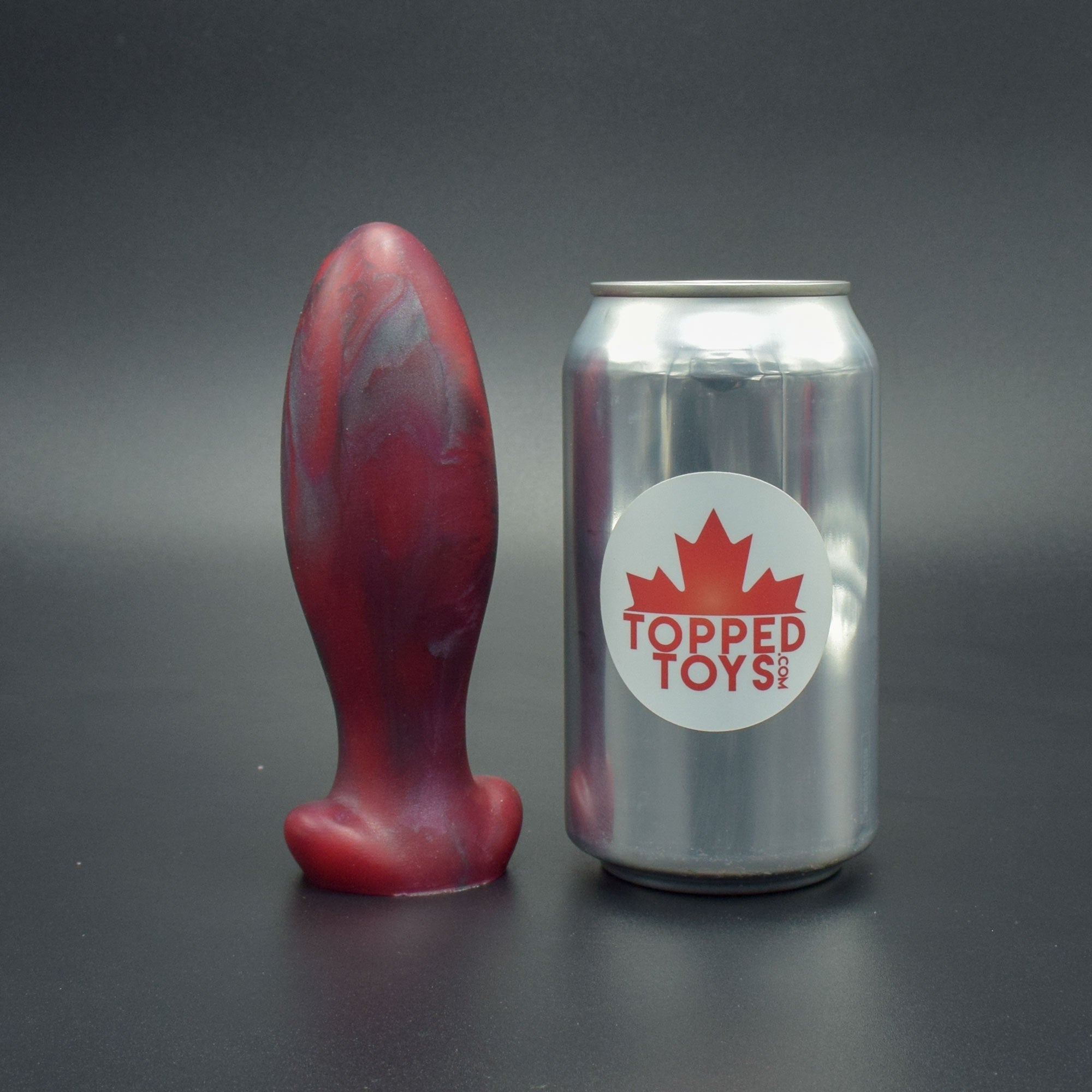 Gape Keeper 55 in Forge Red, next to pop can with Topped Toys logo