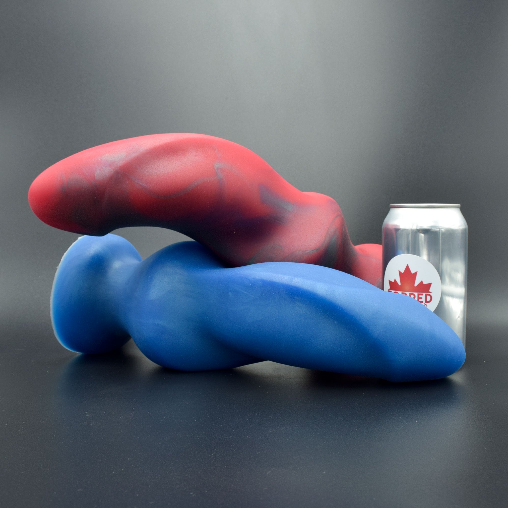 Hilt 125 in Forge Red laying atop a Hilt 125 in Blue Steel, next to pop can with Topped Toys logo
