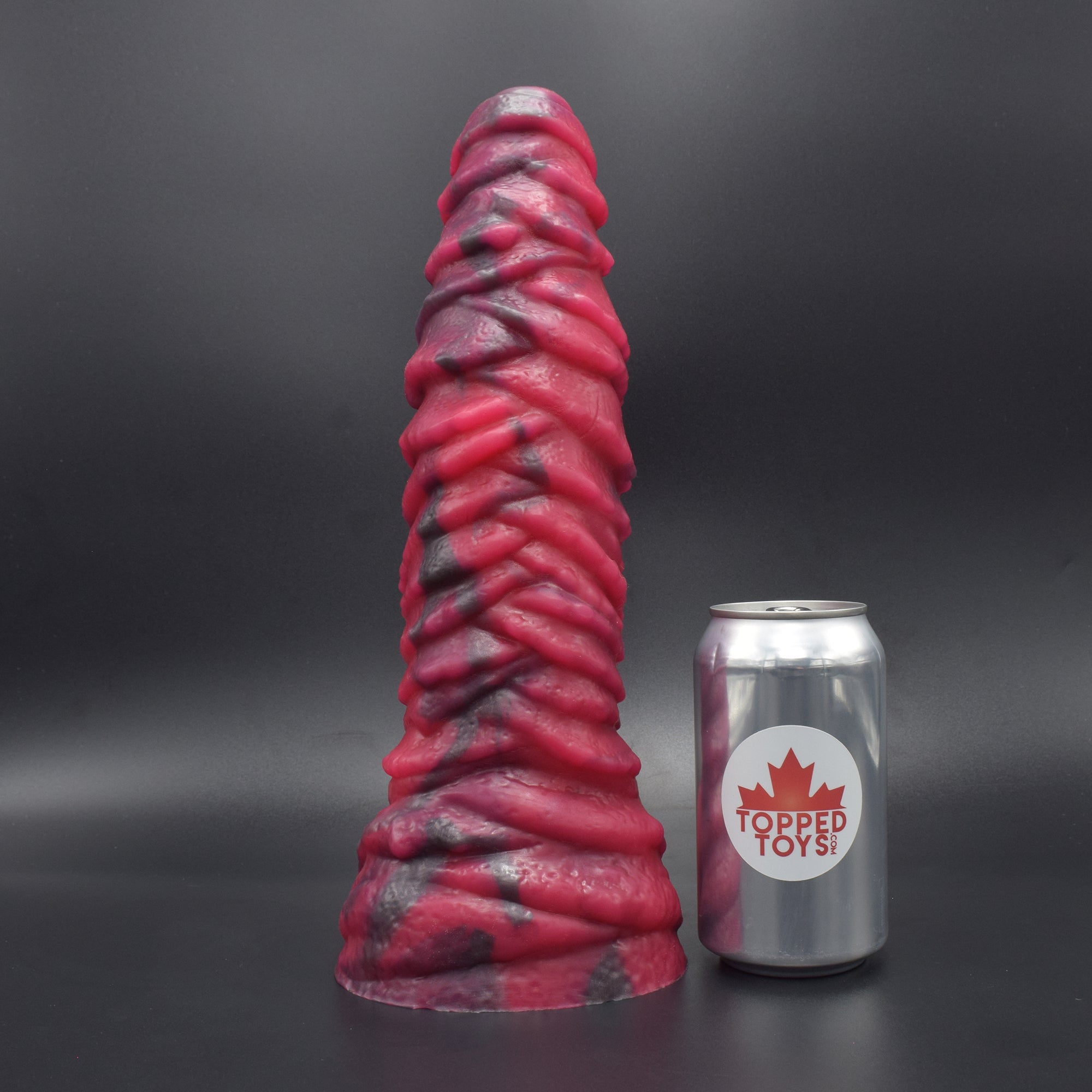 Mordax 105 in Forge Red facing away to show detail, next to popcan with Topped Toys logo