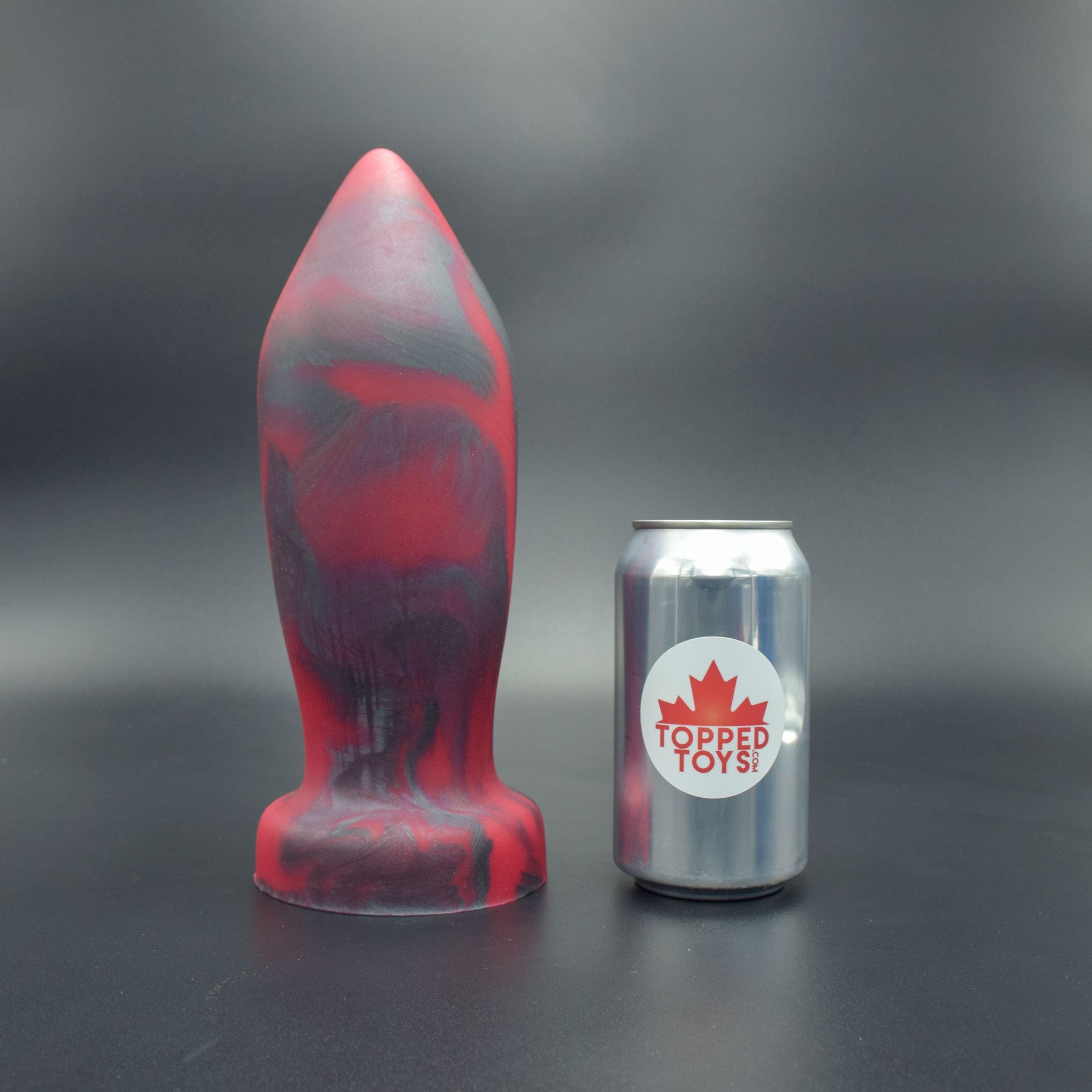 Deep Space 110 in Forge Red standing up, next to pop can with Topped Toys logo