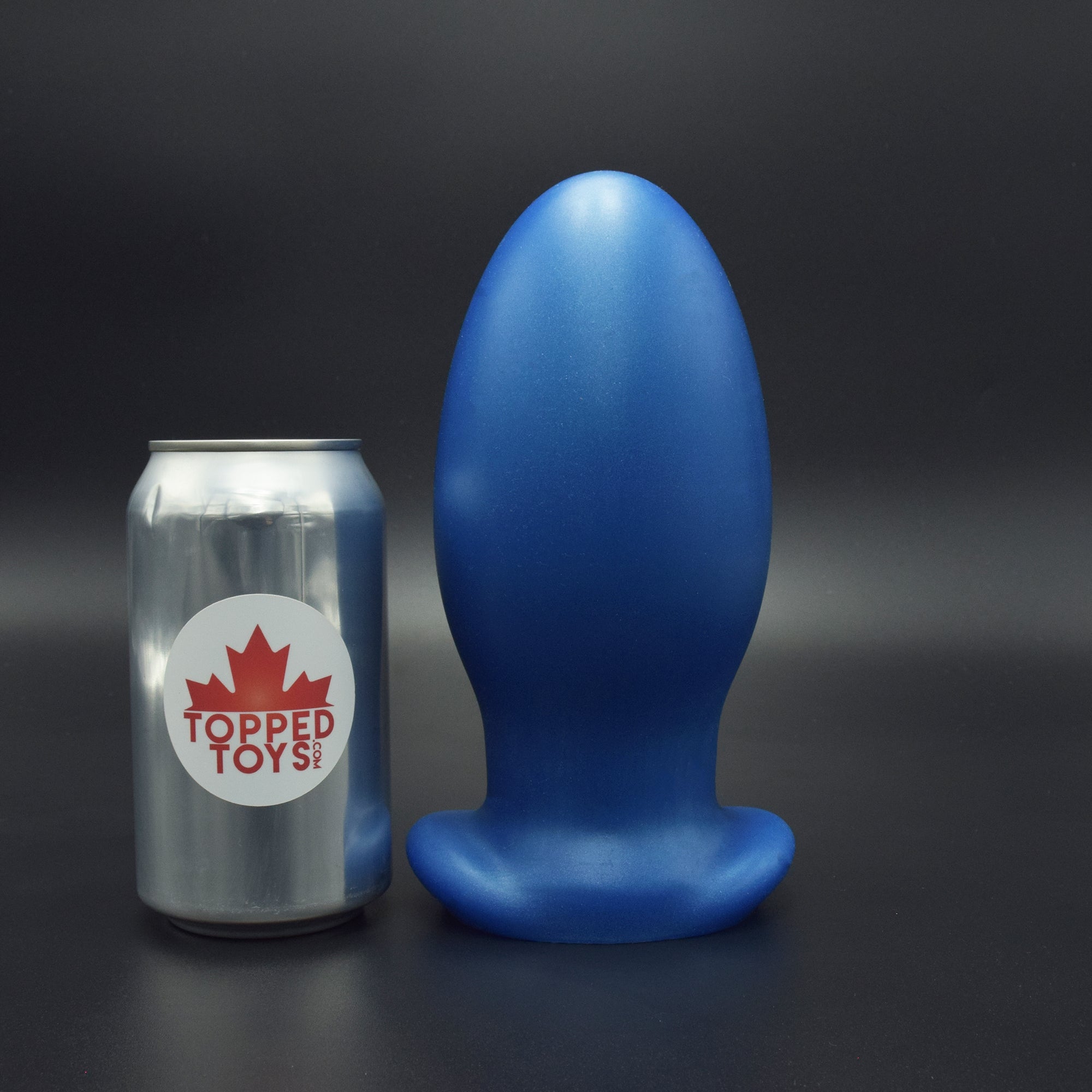 Gape Keeper 108 in Blue Steel standing up, next to pop can with Topped Toys logo