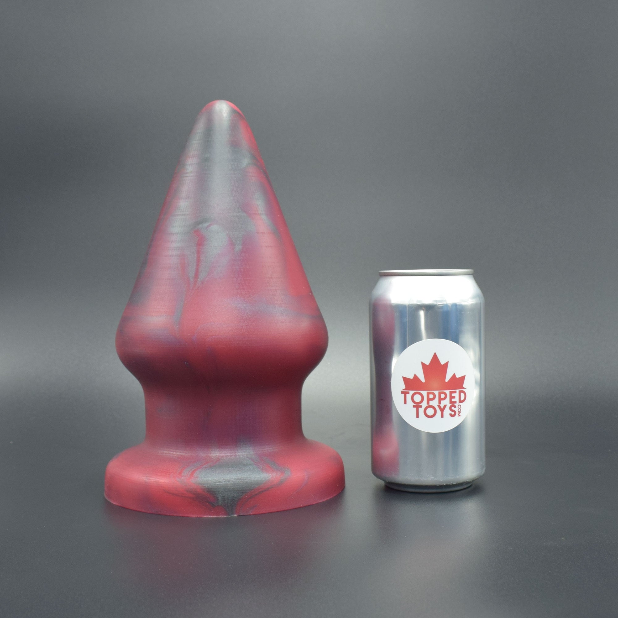 Grip 150 in Forge Red, next to pop can with Topped Toys logo